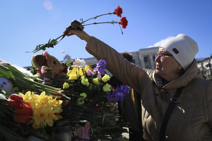 Persone che depongono fiori in memoria delle vittime dell'attacco compiuto a Mosca