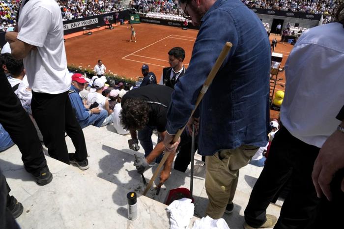 Gli steward impegnati nella pulizia degli spalti dalla vernice (Foto LaPresse)