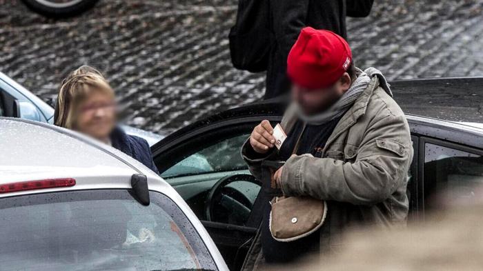 Un parcheggiatore abusivo riceve i soldi da un'automobilista. Foto di repertorio LaPresse