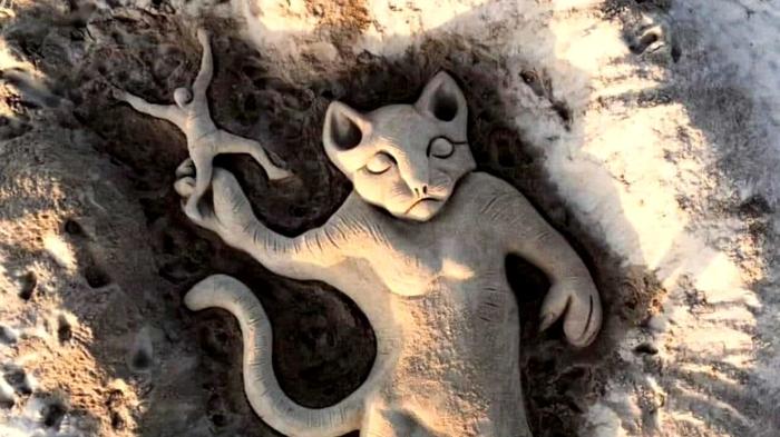 Scultura di sabbia: gatto e uomo