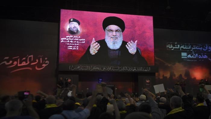 I sostenitori alzano i pugni e applaudono durante un discorso del leader di Hezbollah, Sayyed Hassan Nasrallah.- foto Lapresse  (AP Photo/Mustafa Jamalddine)